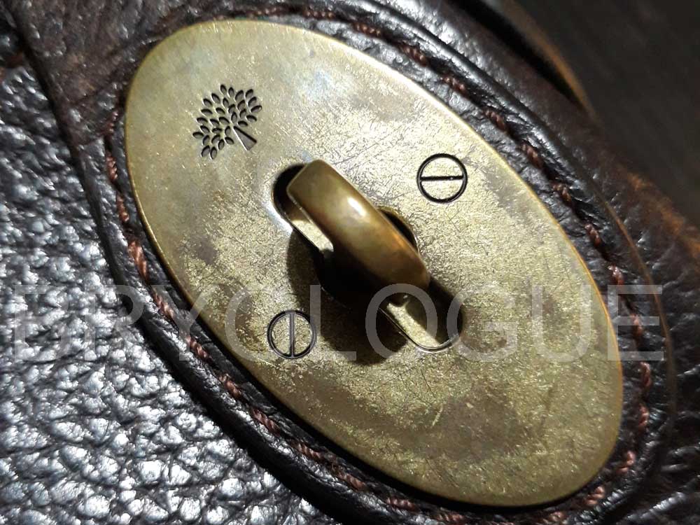 Detail of the Mulberry tree logo on the disc of the Mulberry postman's lock